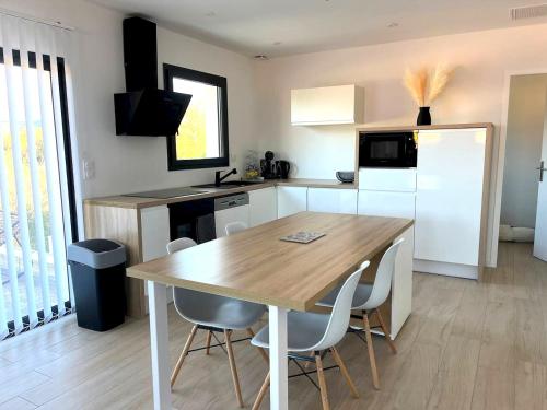 a kitchen with a wooden table and white appliances at Villa accueillante à Millas avec piscine privée et jacuzzi in Millas