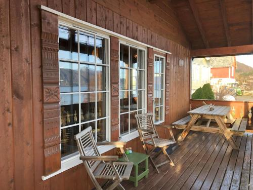 a porch of a cabin with chairs and a table at Cosy chalet, 100m2 with fjordview! in Lauvstad