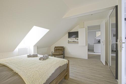 une chambre blanche avec un lit et une chaise dans l'établissement F2 hypercentre - Proche gare - WIFI gratuite, au Havre