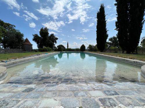 un bassin d'eau avec des arbres en arrière-plan dans l'établissement Location gîtes château Couronneau, à Ligueux