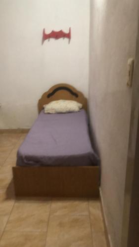 a small bed in a corner of a room at Zapala departamentos por día in Zapala