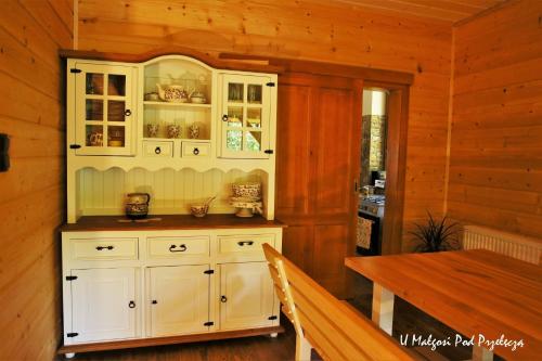 a kitchen with a white cabinet and a table at U Małgosi pod przełęczą in Wysowa-Zdrój