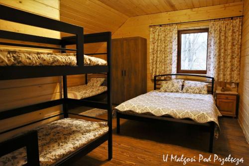 a bedroom with two bunk beds and a window at U Małgosi pod przełęczą in Wysowa-Zdrój