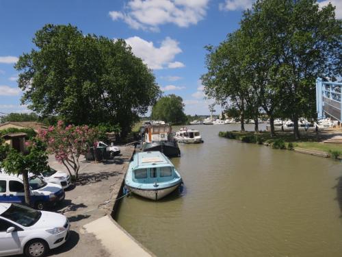 un bateau est amarré dans une rivière avec des voitures garées dans l'établissement Apartment Château de Jouarres-4 by Interhome, à Azille