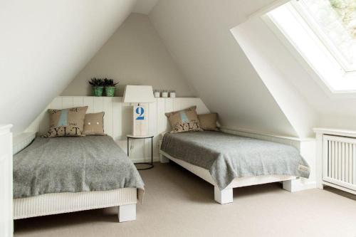 a attic bedroom with two beds and a window at Home-by-Sea in Westerland (Sylt)