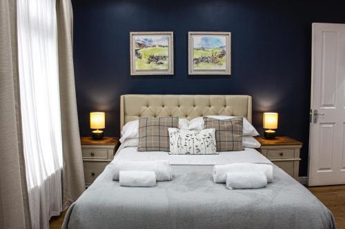 1 dormitorio con 1 cama grande y paredes azules en Elegant 4 bedroom, Maidstone house by Light Living Serviced Accommodation, en Maidstone