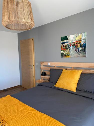 a bedroom with a bed and a painting on the wall at CHAMBRES D'HOTES Chez Nicole et Christian in Villaz