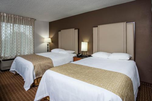 a hotel room with two beds and a window at Travelodge by Wyndham Fort Wayne North in Fort Wayne