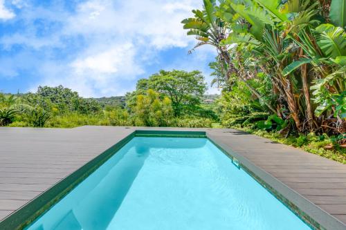 uma piscina de beiral infinito numa villa com árvores em Baluwatu 10, Zimbali Estate em Ballito