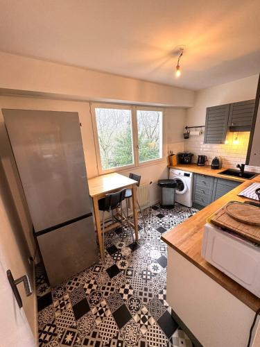 a kitchen with a counter and a table in it at Appartement Cosy Luxury with Lake in Brunoy