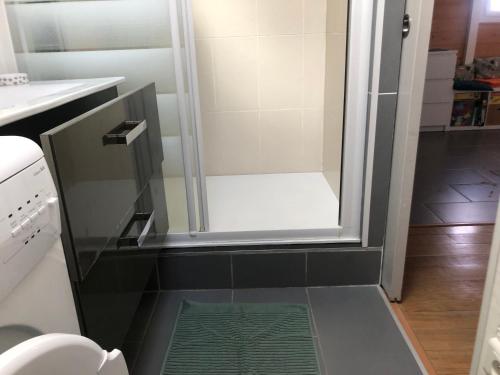 une douche avec une porte vitrée dans une salle de bain dans l'établissement Les portes de la Plage, à Port-Leucate