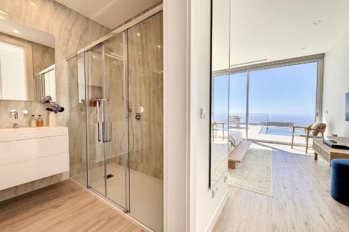 a bathroom with a shower with a view of the ocean at Villa OceanAIR by LovelyStay in Prazeres
