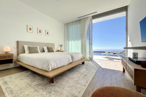 a bedroom with a bed and a view of the ocean at Villa OceanAIR by LovelyStay in Prazeres