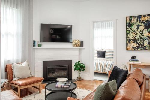 a living room with a couch and a fireplace at Mulgrave Street Cottage- renovated comfort in Kings Park