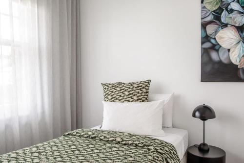 a white bedroom with a bed and a window at Mulgrave Street Cottage- renovated comfort in Kings Park