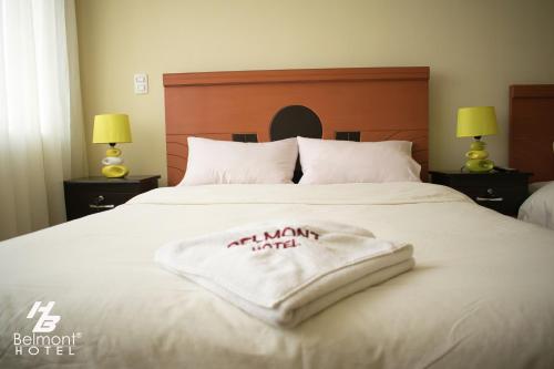 a bed with a white towel on top of it at Belmont B&B in La Paz