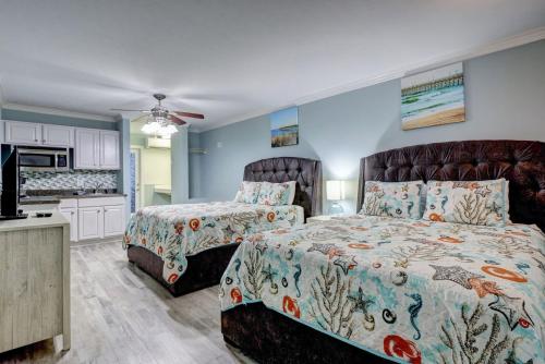 1 dormitorio con 2 camas y cocina en Unit 102D at Tiffany's, en Surf City