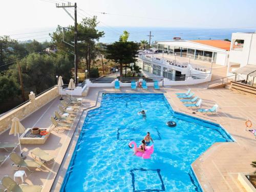 a swimming pool with a person in a pink raft at Adele Resort in Adelianos Kampos