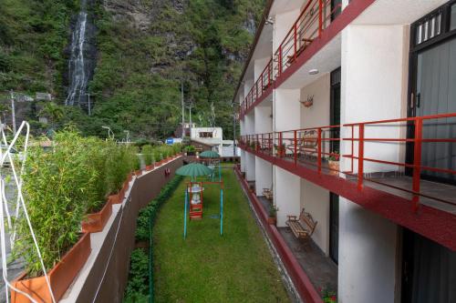 a balcony of a building with a waterfall in the background at Sangay Spa Hotel in Baños