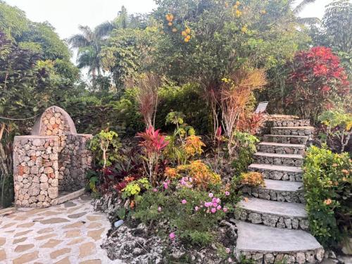 Caracol Los Farallones في Catalinas: حديقة بها مسار حجري وزهور