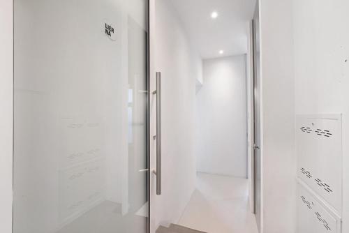 a glass shower door in a white room at Dimora Lierna in Lecco