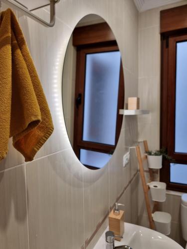 ein Badezimmer mit einem Spiegel und einem Waschbecken in der Unterkunft a 2 min de Gascona in Oviedo