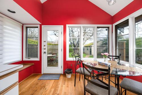 a kitchen with red walls and a table and chairs at Tranquil Haven near Attractions 2BD Upper Floor or 2BD Basement Floor in Vancouver
