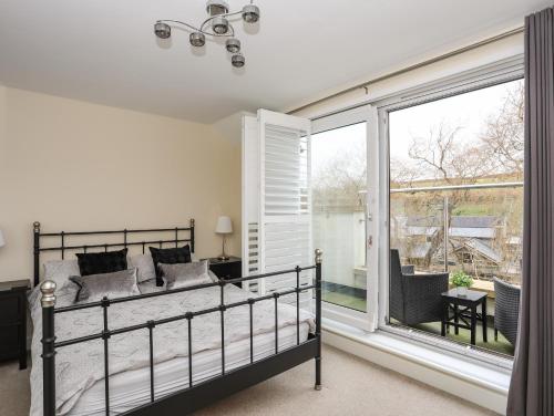 a bedroom with a bed and a large window at Arnant in Pwllheli