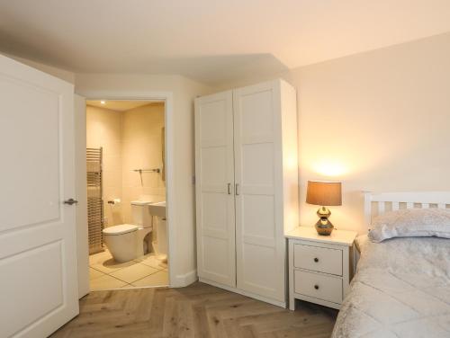 a bedroom with a bed and a bathroom with a toilet at Arnant in Pwllheli