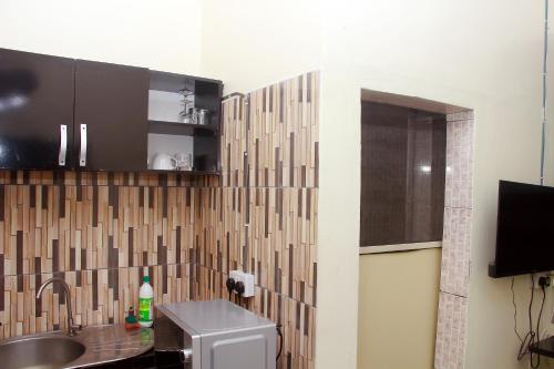 a small kitchen with a sink and a sink at Smilley's Place Roffi in Lagos