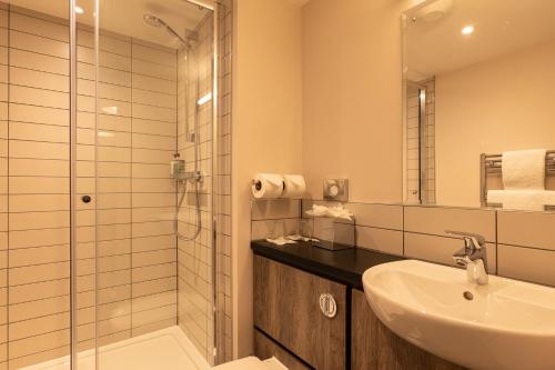 a bathroom with a sink and a glass shower at Offshore - The Inn Collection Group in Lytham St Annes