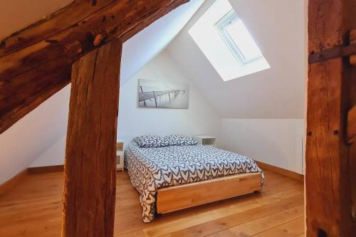 une chambre avec un lit dans un grenier dans l'établissement COSY + COOL BURGUNDY, à Beaune