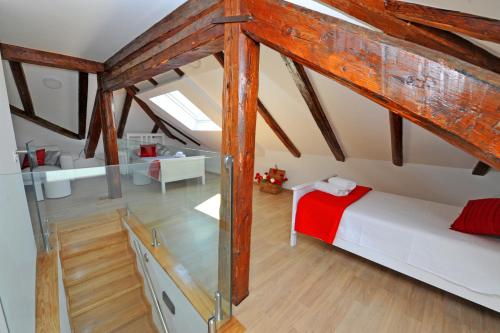 1 dormitorio en el ático con cama y vigas de madera en Luxury Rooms Nirvana, en Split