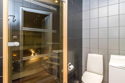 een badkamer met een toilet en een glazen douchedeur bij Vuokatti Weekend Piste in Vuokatti