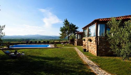 a stone house with a swimming pool in a yard at LOS VAGONES 1 in Vatopedi