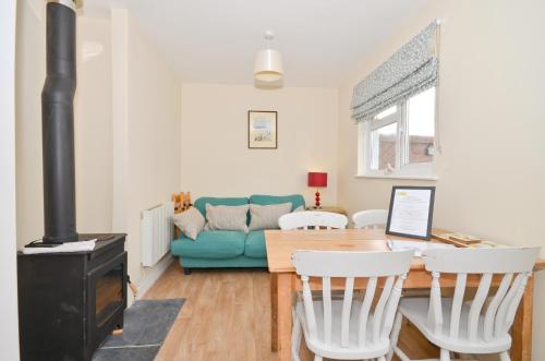a living room with a table and a blue couch at 24 Tollgate Cottages in Seaview