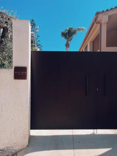 a large black garage door in front of a house at ALFIEA HOME 65m2 & ALFIEA STUDIO 35m2 in Artemida