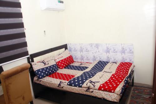 a bed with red white and blue pillows on it at Smilley's Place Ms-Tammy in Lagos