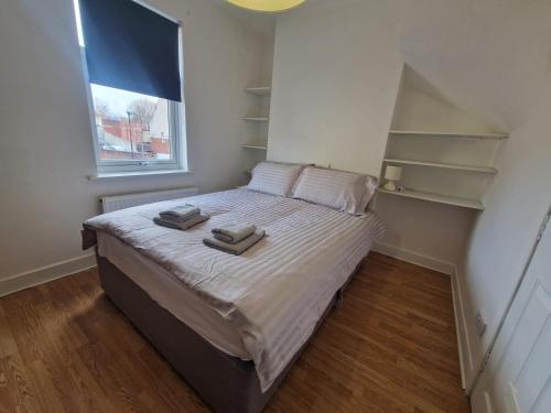 a bedroom with a bed with two towels on it at Suite 1: Cosy Room in a Prime Location in Sheffield