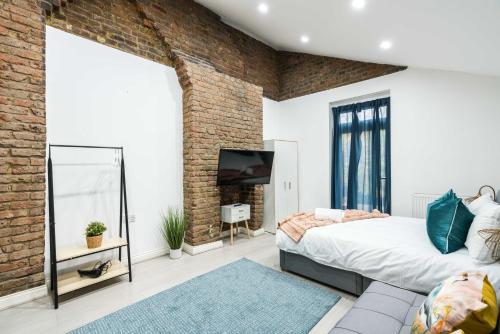 a bedroom with a brick wall and a bed and a mirror at Central-comfyStudio-quite in London