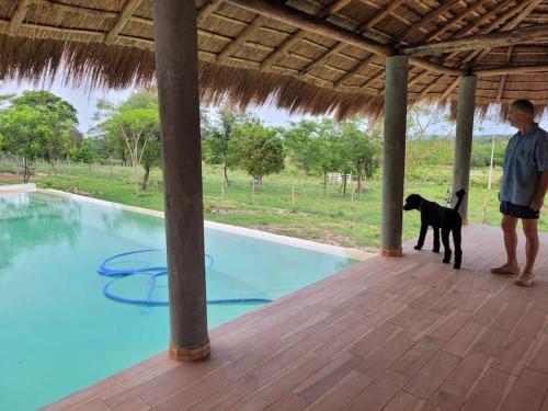 een man en een hond die naast een zwembad staan bij Luxux Ferienwohnung Indepedencia Casa Blanca No.3 in Independencia