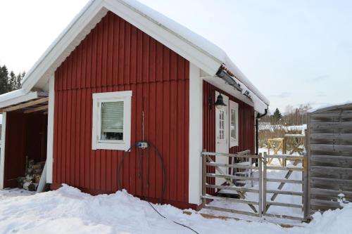 a red building with snow on the ground in front at Holiday house in nature-filled Vidja, near Stockholm City in Farsta