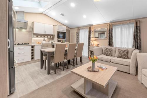 a kitchen and living room with a table and a couch at Dizzy Ducks Lodge in Windermere