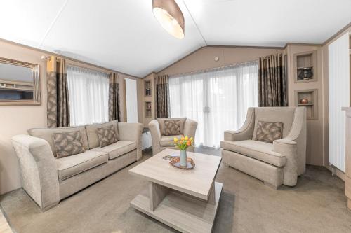 a living room with couches and a coffee table at Dizzy Ducks Lodge in Windermere