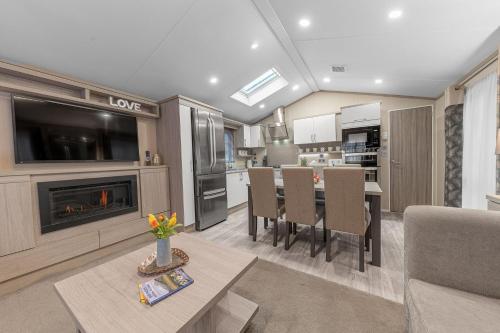 a living room with a kitchen and a dining room at Dizzy Ducks Lodge in Windermere