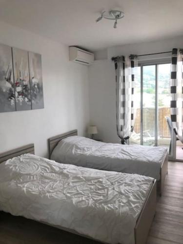 deux lits jumeaux dans une chambre avec fenêtre dans l'établissement T3 classé 3 * vue mer parking 100 m plage/ville, au Lavandou