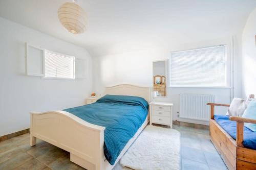 a white bedroom with a bed and a window at Family Haven by the Waves Direct Beach Access in Pevensey