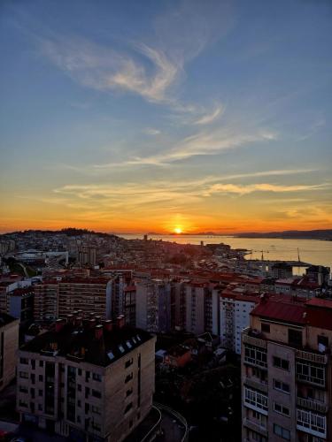 a view of a city with the sunset in the background at VistasAragon in Vigo