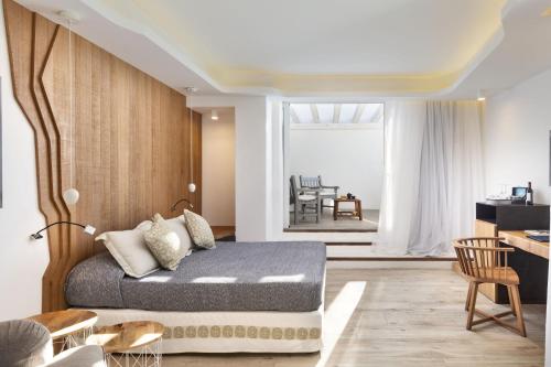 a bedroom with a bed and a dining room at Hotel Grand Relais Dei Nuraghi in Baja Sardinia