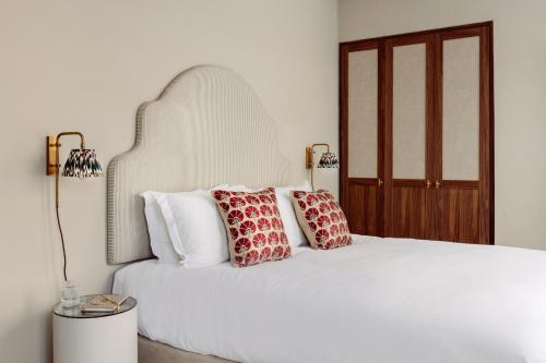 a bedroom with a white bed with red pillows at Native Kings Wardrobe, St Pauls in London